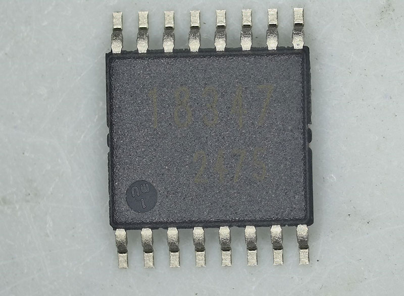 Top-down view of an integrated circuit showing package surface texture and faint laser markings for refurbishment detection.